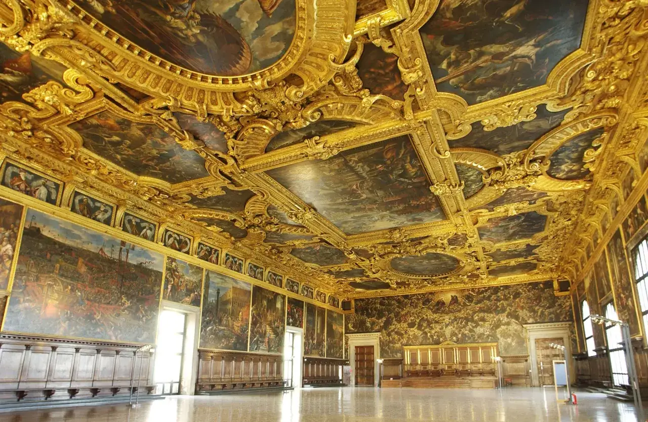 L'opulence dor&eacute;e du **Palais des Doges &agrave; Venise** se r&eacute;v&egrave;le sous un plafond peint et sculpt&eacute;, ornant une salle majestueuse.