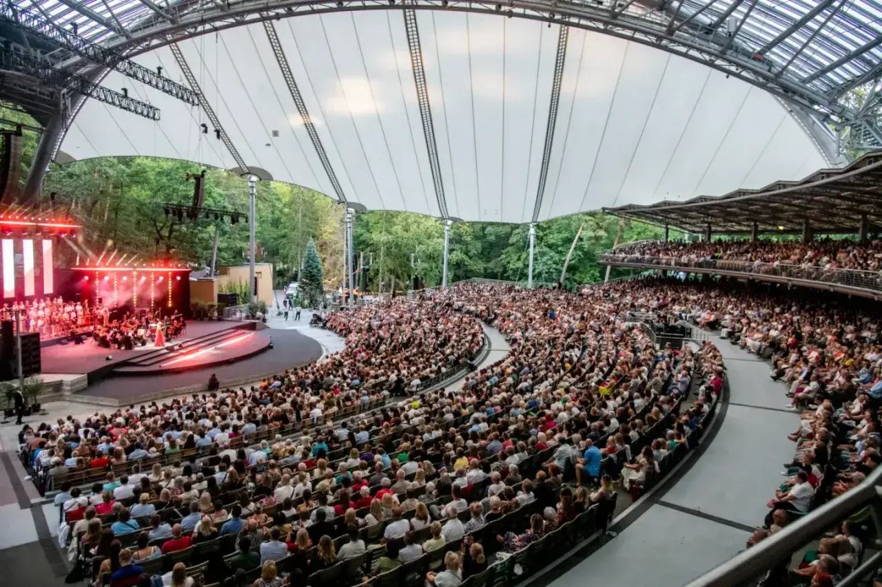 Koncert z okazji urodzin Wodeckiego w amfiteatrze. Tłumy widzów na widowni, na scenie orkiestra i chór.