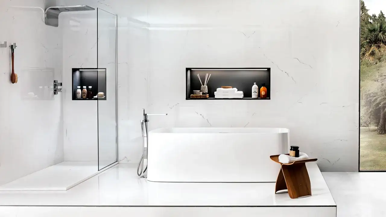 Bagno moderno con doccia e vasca. Nicchie design integrate nelle pareti bianche ospitano prodotti da bagno e asciugamani.