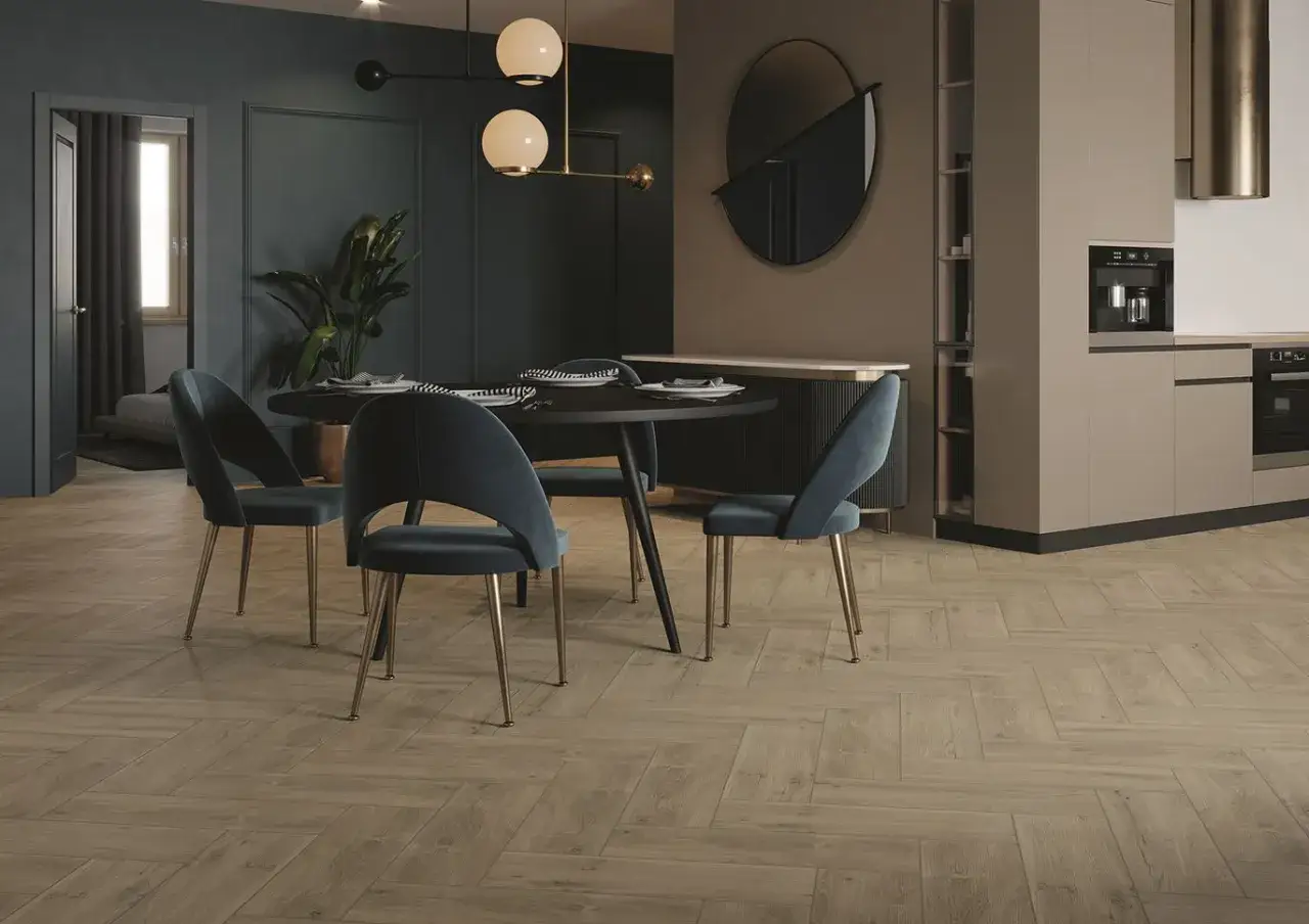 Elegancka jadalnia z granatowymi krzesłami i okrągłym stołem, inspirowana paletą kolorów Dekoral. Drewniana podłoga w jodełkę tworzy przytulną atmosferę.