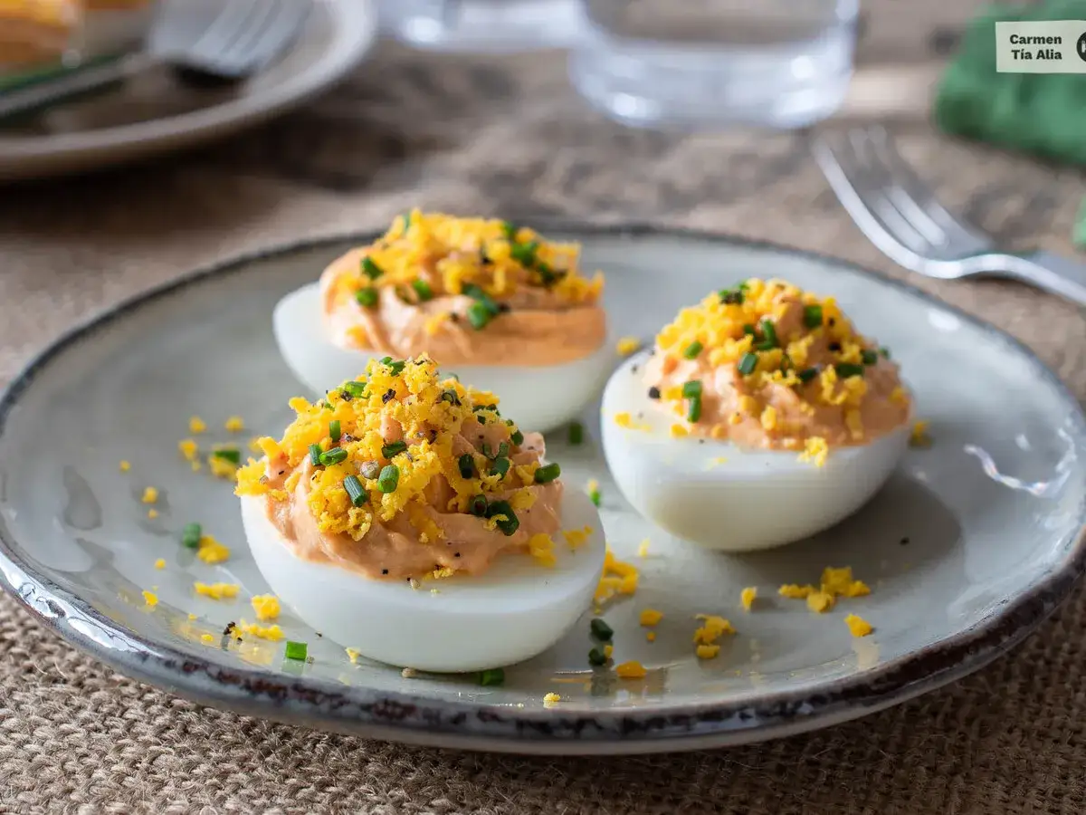 Huevos rellenos de at&uacute;n, decorados con ralladura de huevo y cebollino. Un aperitivo delicioso y f&aacute;cil de preparar.
