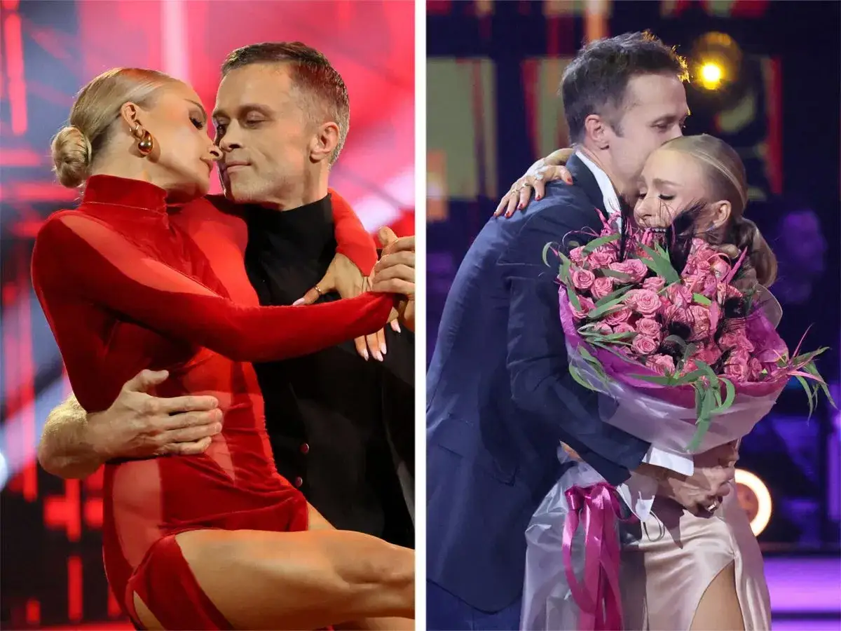 Sara Janicka i jej mąż w romantycznym uścisku na scenie. Ona w czerwonej sukni, on w garniturze, trzyma bukiet róż.