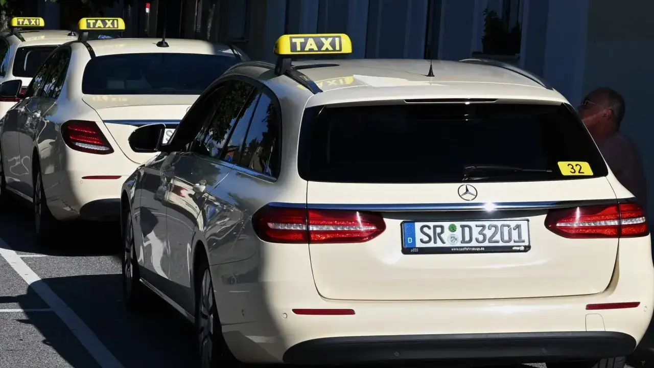Mehrere wei&szlig;e Taxis stehen in einer Reihe. Die gelben 