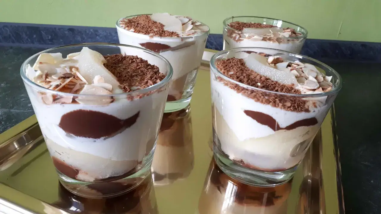 Quatre verrines poire chocolat mascarpone, garnies de copeaux de chocolat et d'amandes effil&eacute;es. Un d&eacute;lice gourmand !