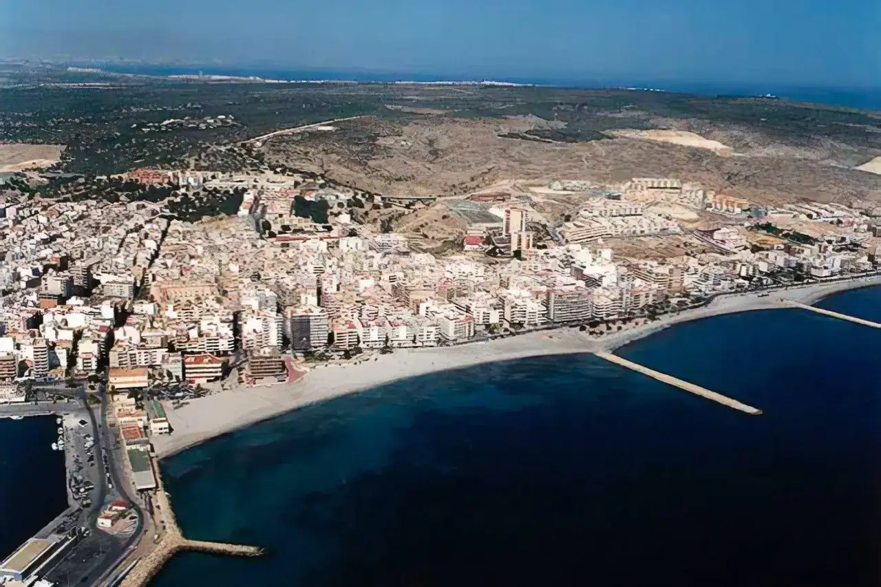 Vista aérea de la **playa Levante Santa Pola**, con edificios blancos y el mar azul.