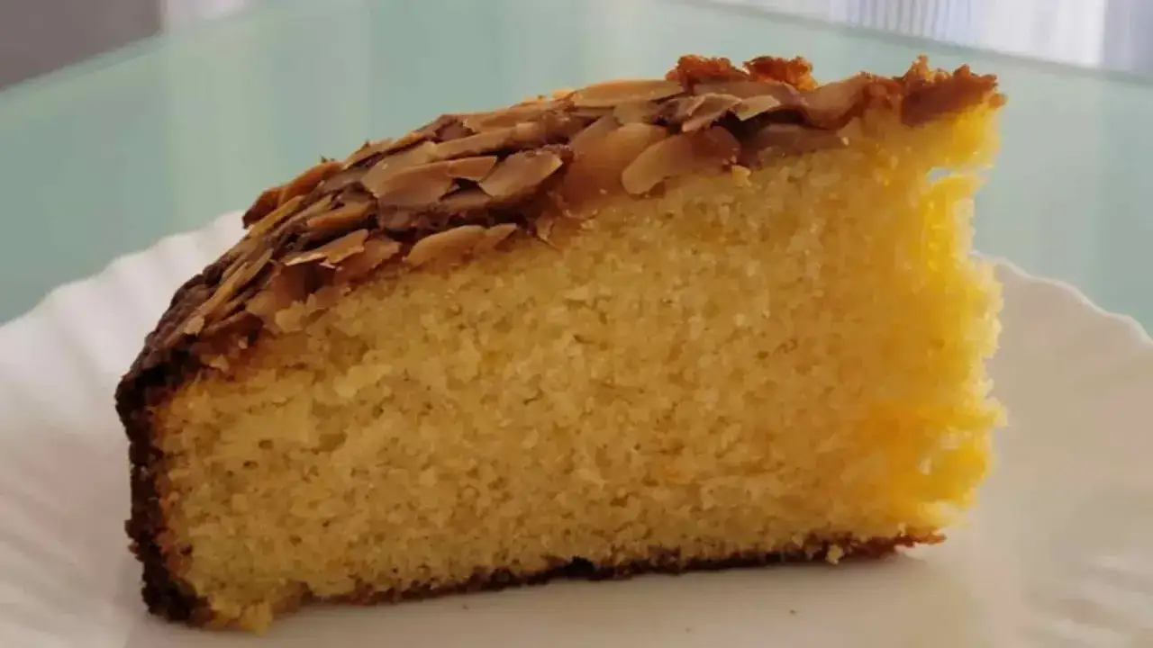 Rebanada de tarta de oro, esponjosa y dorada, cubierta de almendras tostadas. &iexcl;Un manjar!