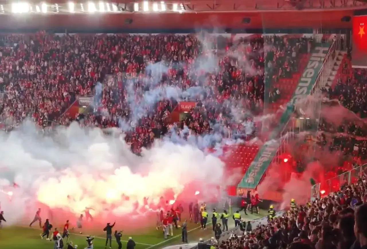 Tłumy kibic&oacute;w SK Slavia Praga świętują, odpalając race i tworząc dym na boisku.
