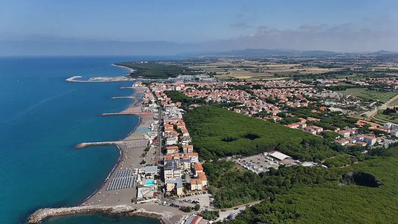 Vista aerea della **marina di Cecina lungomare** con spiagge attrezzate, mare azzurro, pineta e case.