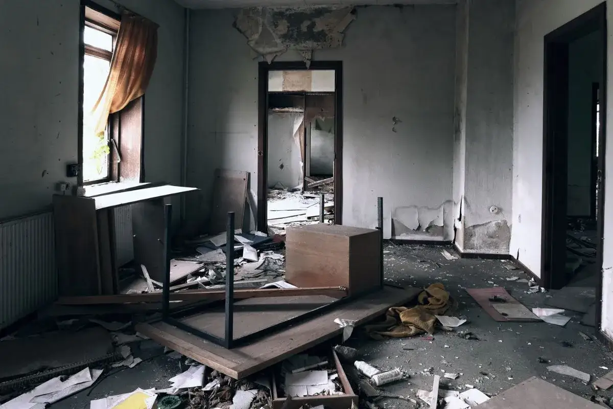 Habitación abandonada con escombros y muebles volcados. Imagina qué pasa si compro un piso ocupado y me encuentro esto.