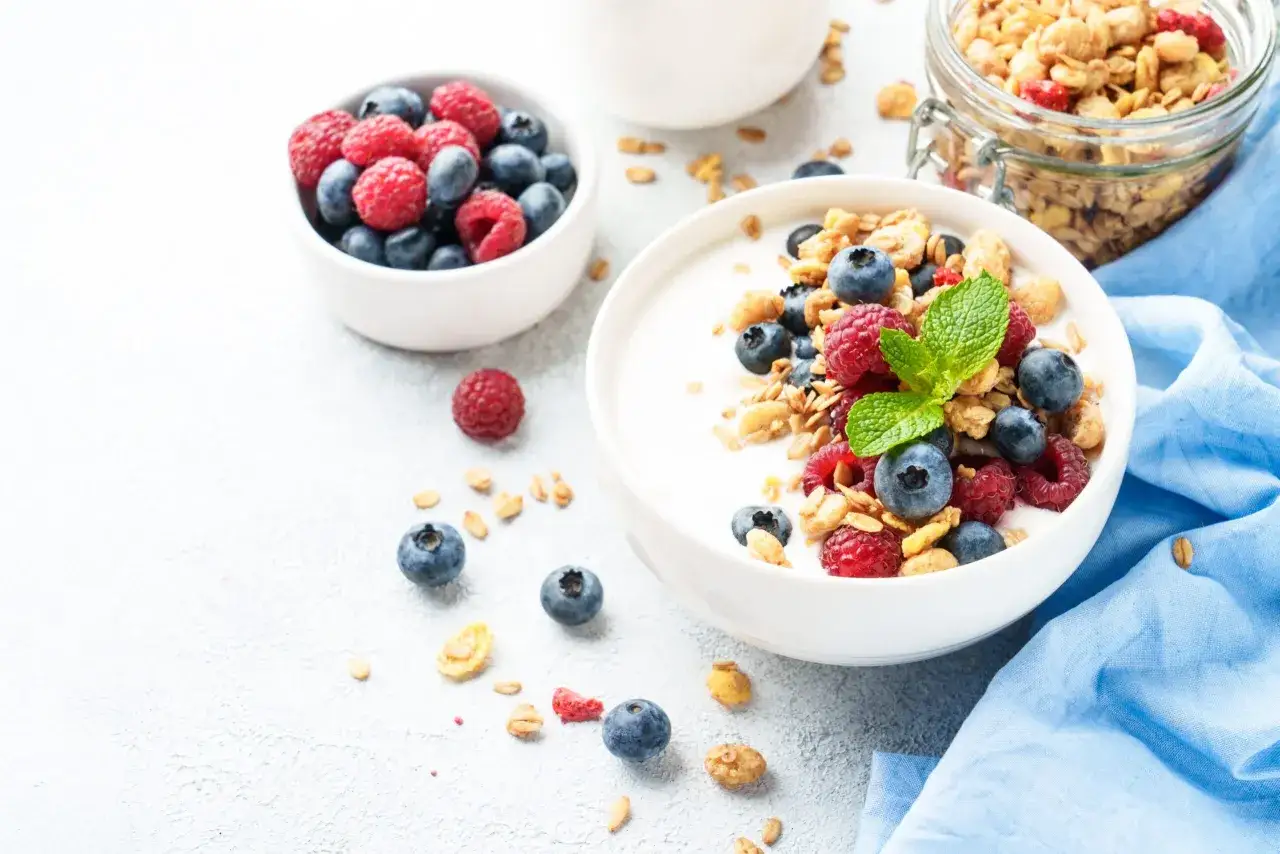 Schüssel mit cremigem skyr oder joghurt, garniert mit frischen Beeren und Müsli. Ein gesunder Start in den Tag.