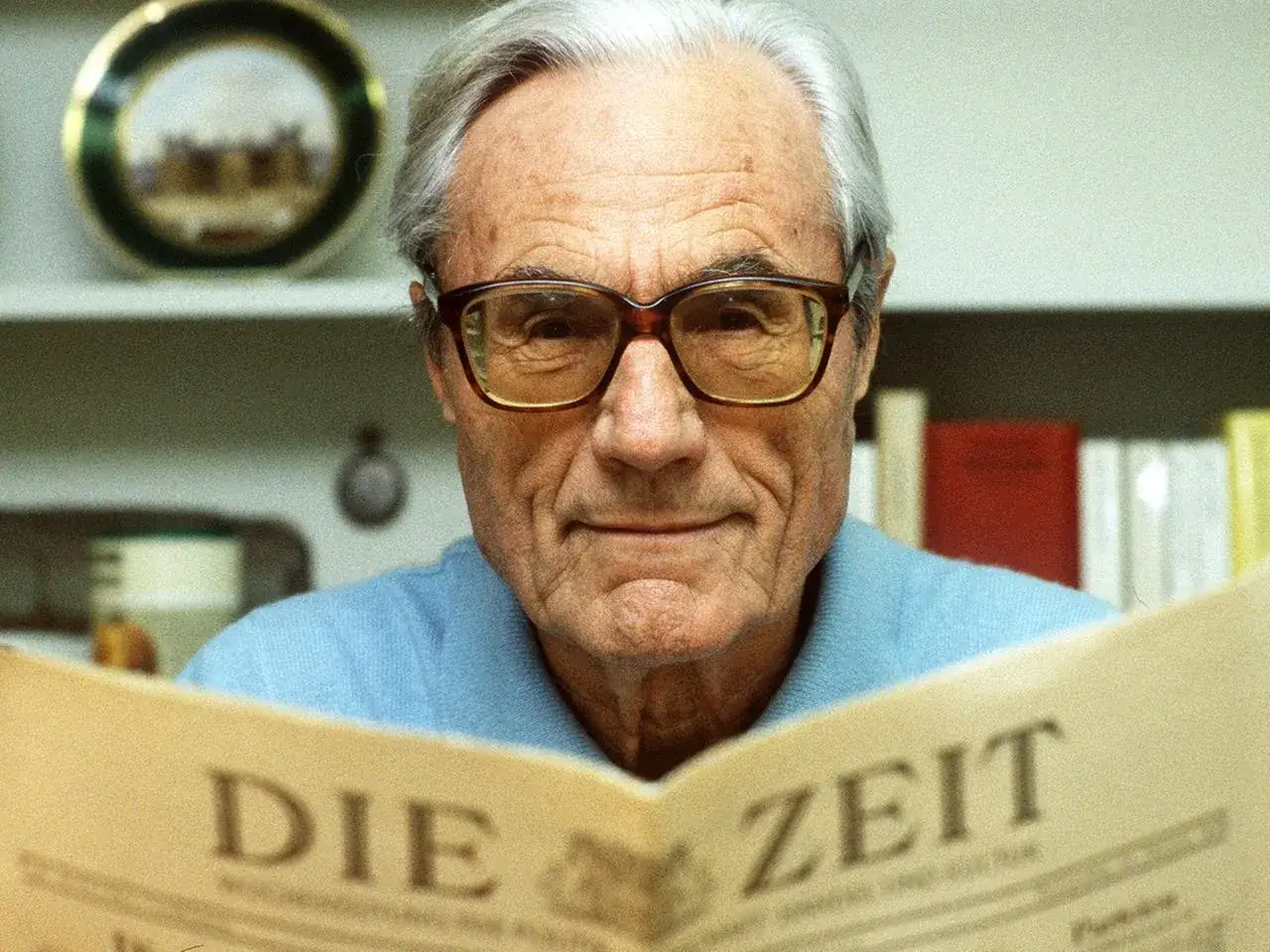 Gerd Bucerius, mit Brille und einem L&auml;cheln, liest die Zeitung 