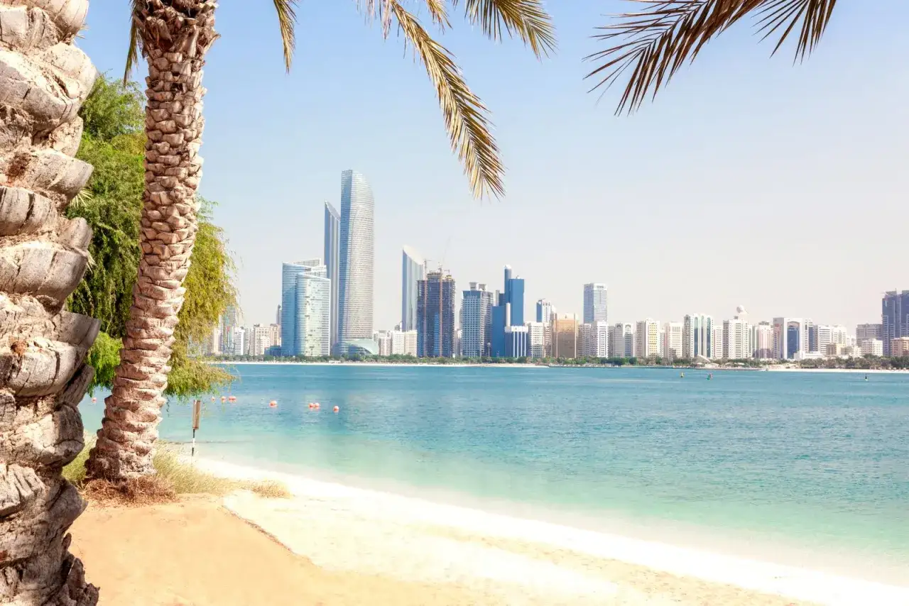 Traumhafter Strand mit Palmen und Blick auf die Skyline von Dubai. Die beste Reisezeit für Dubai ist jetzt!