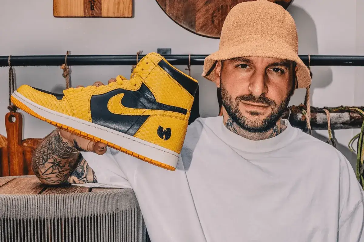 Mężczyzna w kapeluszu trzyma żółto-czarne buty Nike z logo Wu-Tang. Czy to najbrzydsze buty Nike?