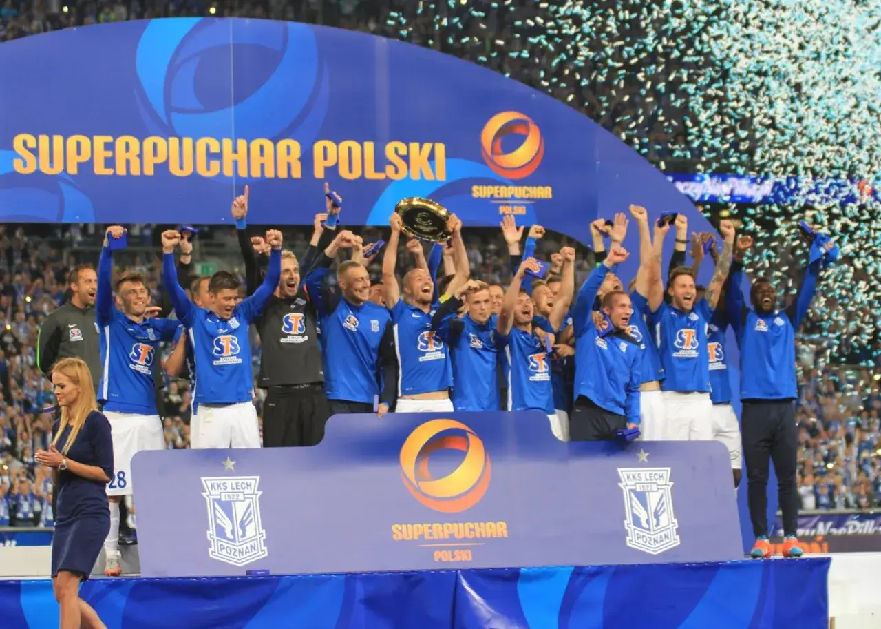 Piłkarze świętują zdobycie Superpucharu Polski, unosząc trofeum i ciesząc się z wygranej wśród konfetti.