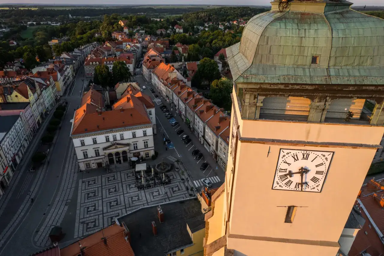 Złotoryja atrakcje: widok z wieży na rynek, kamienice i okolicę. Zegar wskazuje godzinę.