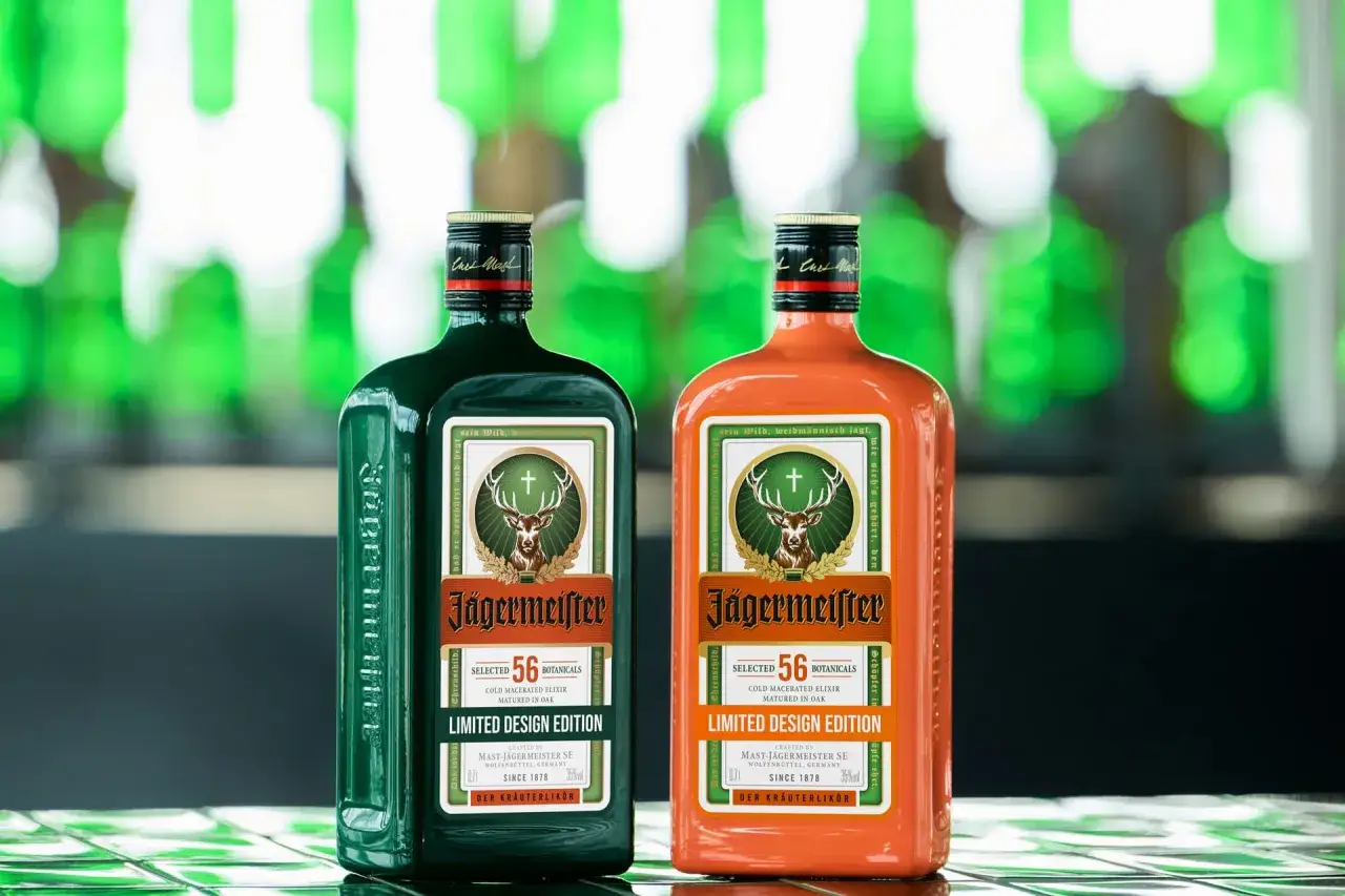 Dwie butelki Jägermeistera: klasyczna zielona i pomarańczowa edycja limitowana. Różne rodzaje tego likieru ziołowego.