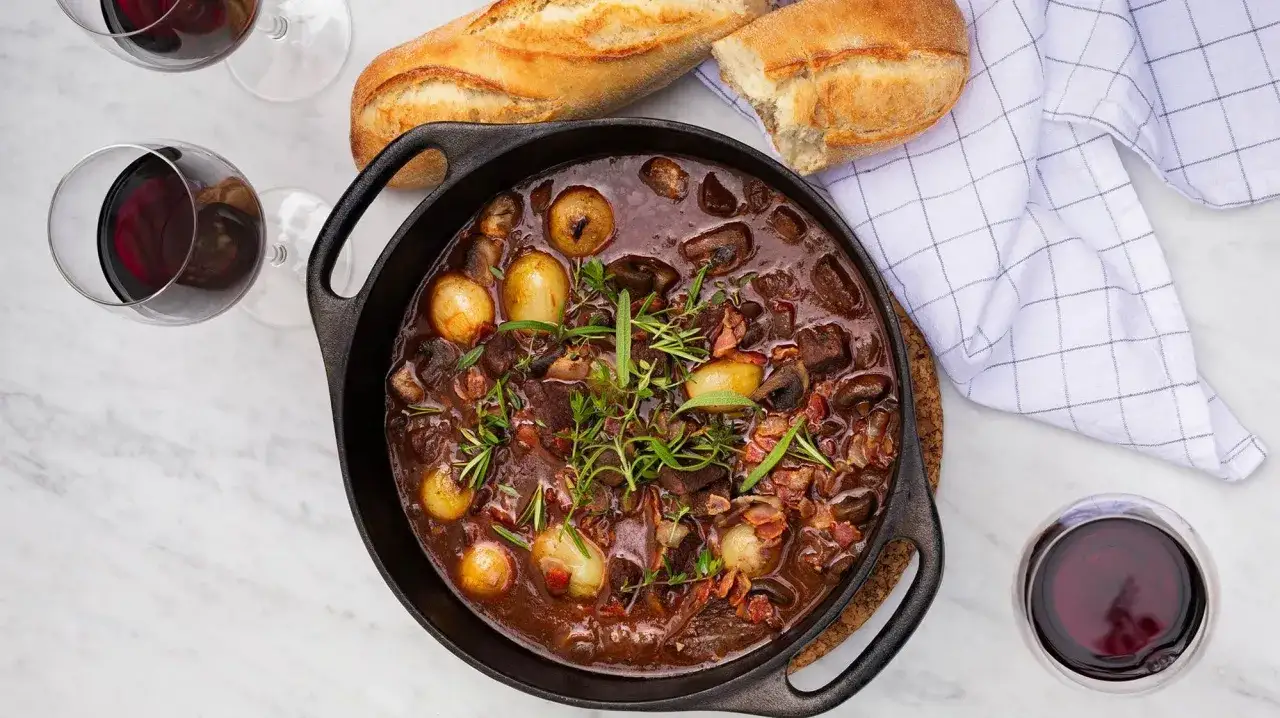 En mustig boeuf bourguignon i gjutj&auml;rnsgryta, med sm&aring; l&ouml;kar, svamp och &ouml;rter. Serveras med baguette och r&ouml;dvin.