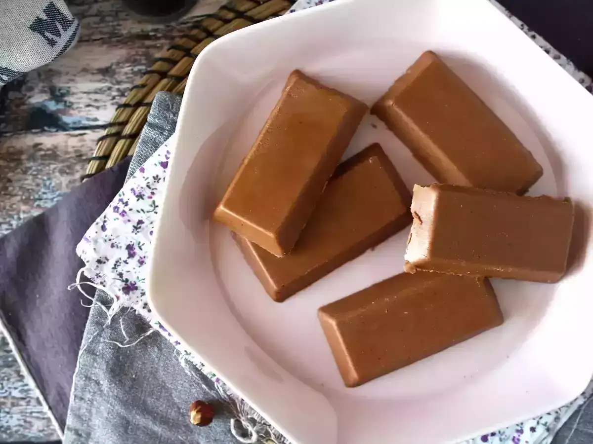 Czekoladki gianduja, czyli to co to jest - pyszne praliny z orzechami laskowymi, na białym talerzyku.