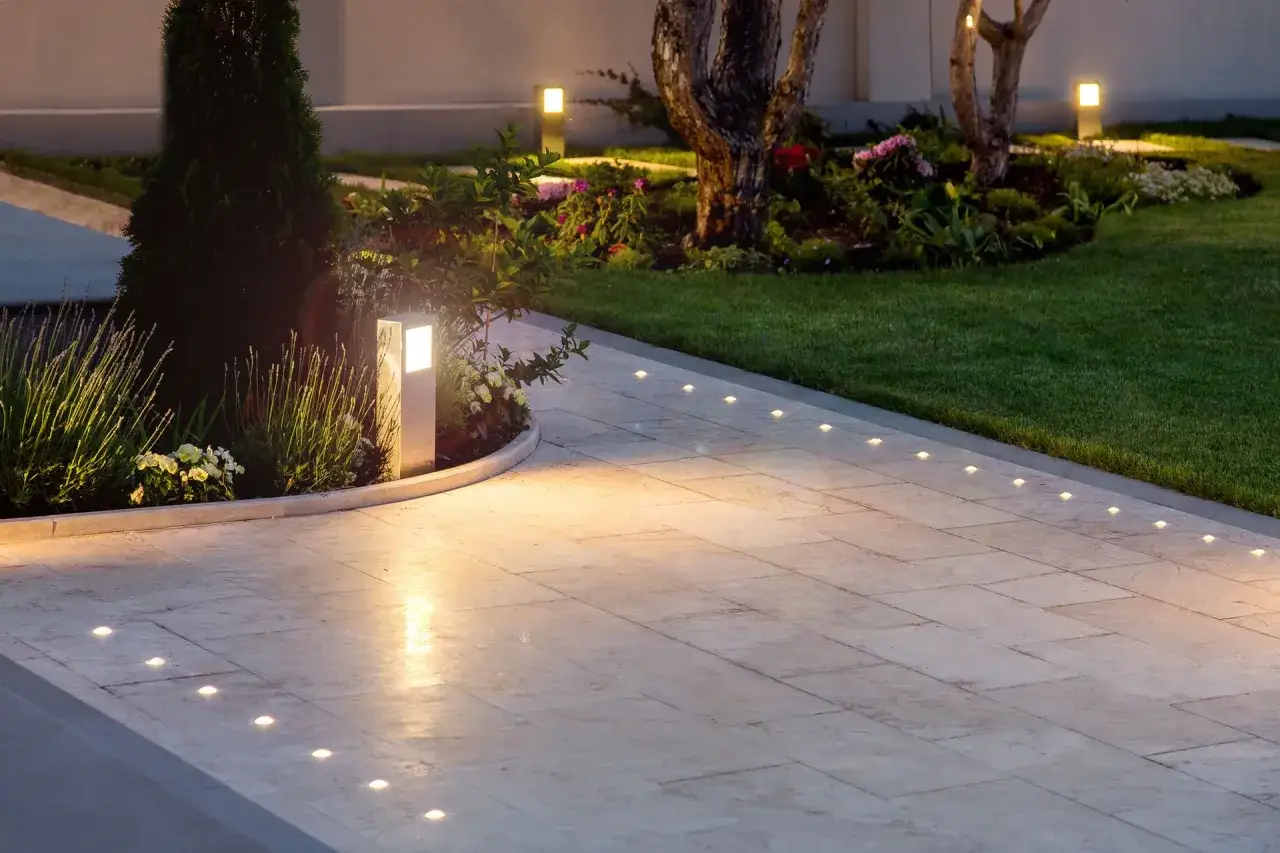 Allée de jardin illuminée par des spots encastrés, respectant la norme éclairage lux pour une ambiance sécurisante et esthétique.