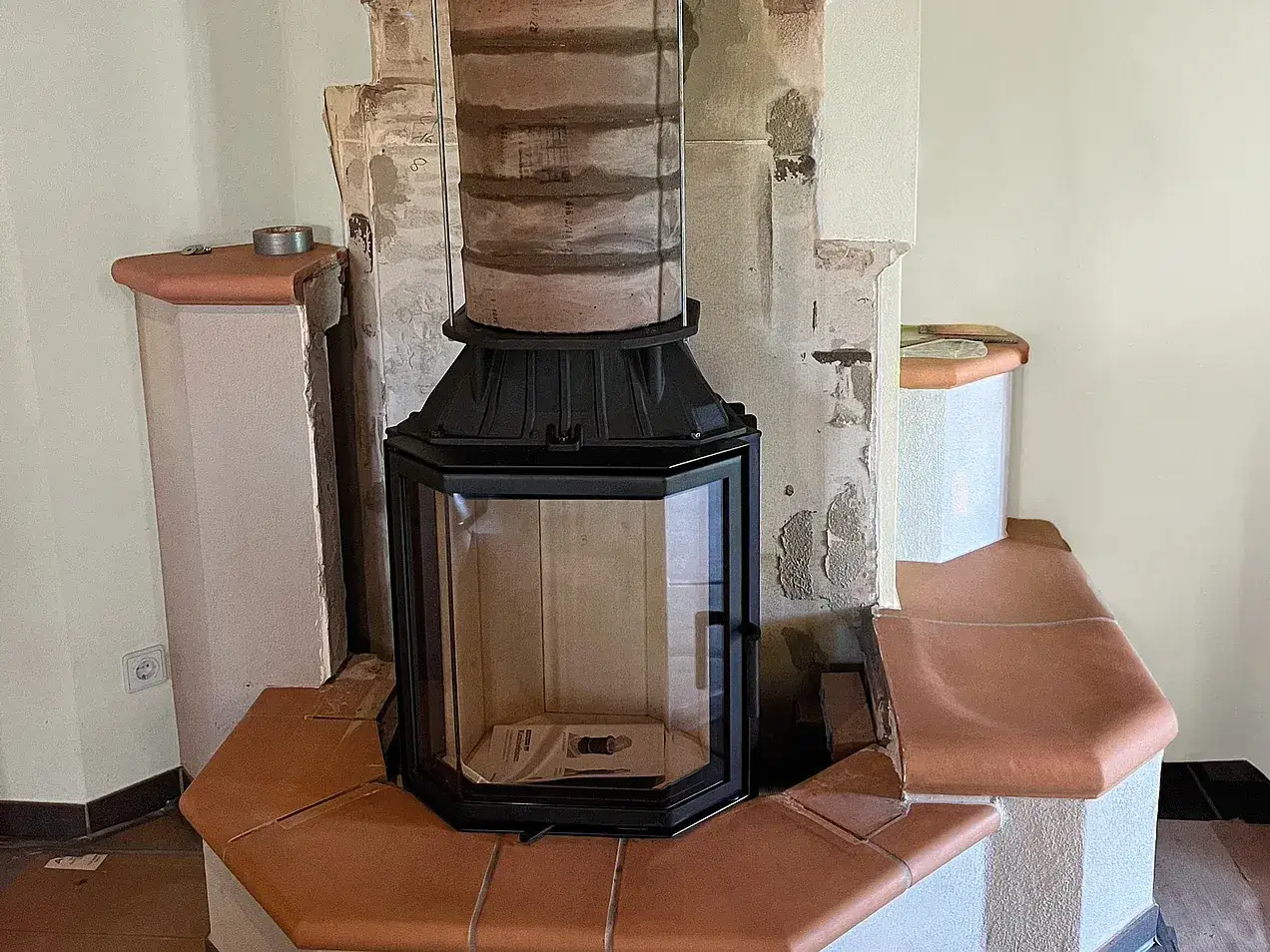 Neuer Kamineinsatz wird montiert. Die Kosten für den Kamin austauschen sind hier im Fokus.