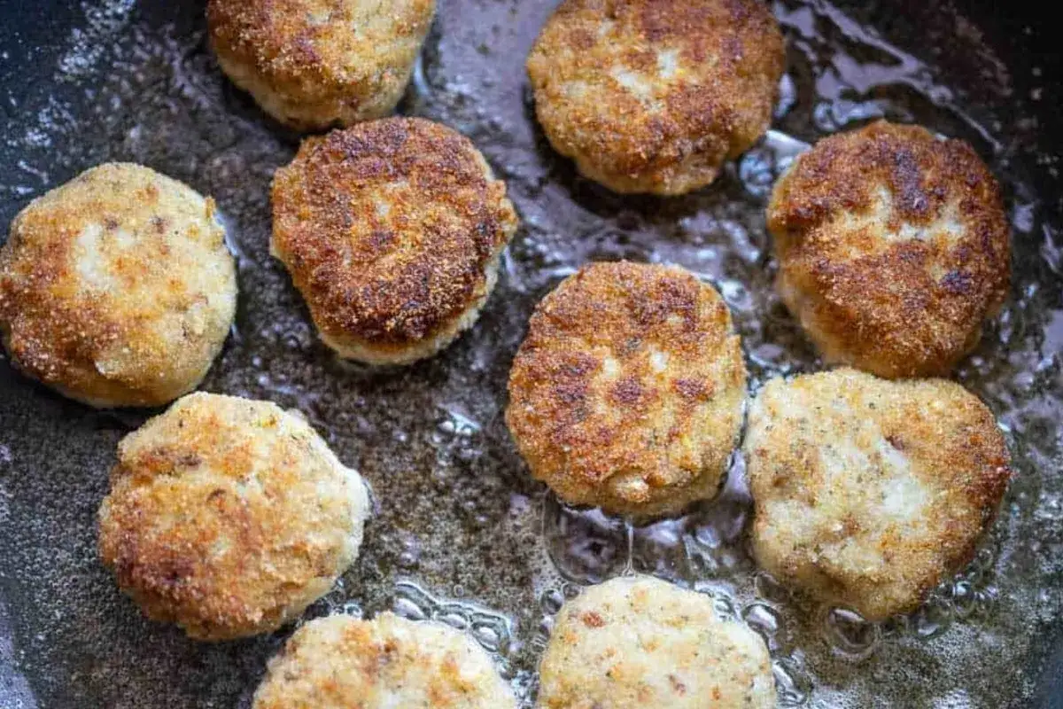 Mehrere goldbraune Frikadellen brutzeln in hei&szlig;em &Ouml;l. Ein k&ouml;stliches Frikadellen Rezept, das Appetit macht.