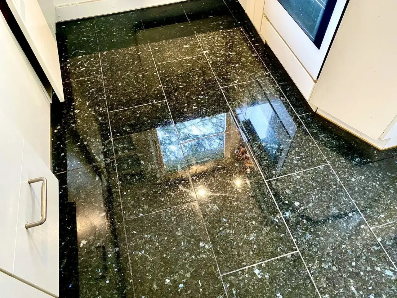 Gl&auml;nzender Granitboden mit eingezogenen Flecken, der nach der Reinigung wieder strahlt.