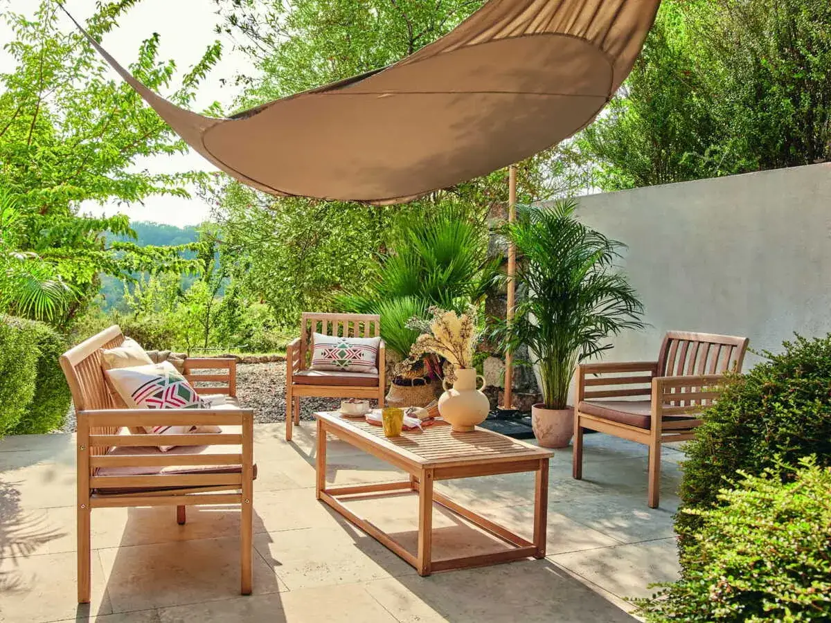 Un coin détente pour aménager votre terrasse : salon en bois, coussins colorés, table basse et voile d'ombrage. Parfait pour se relaxer au soleil.