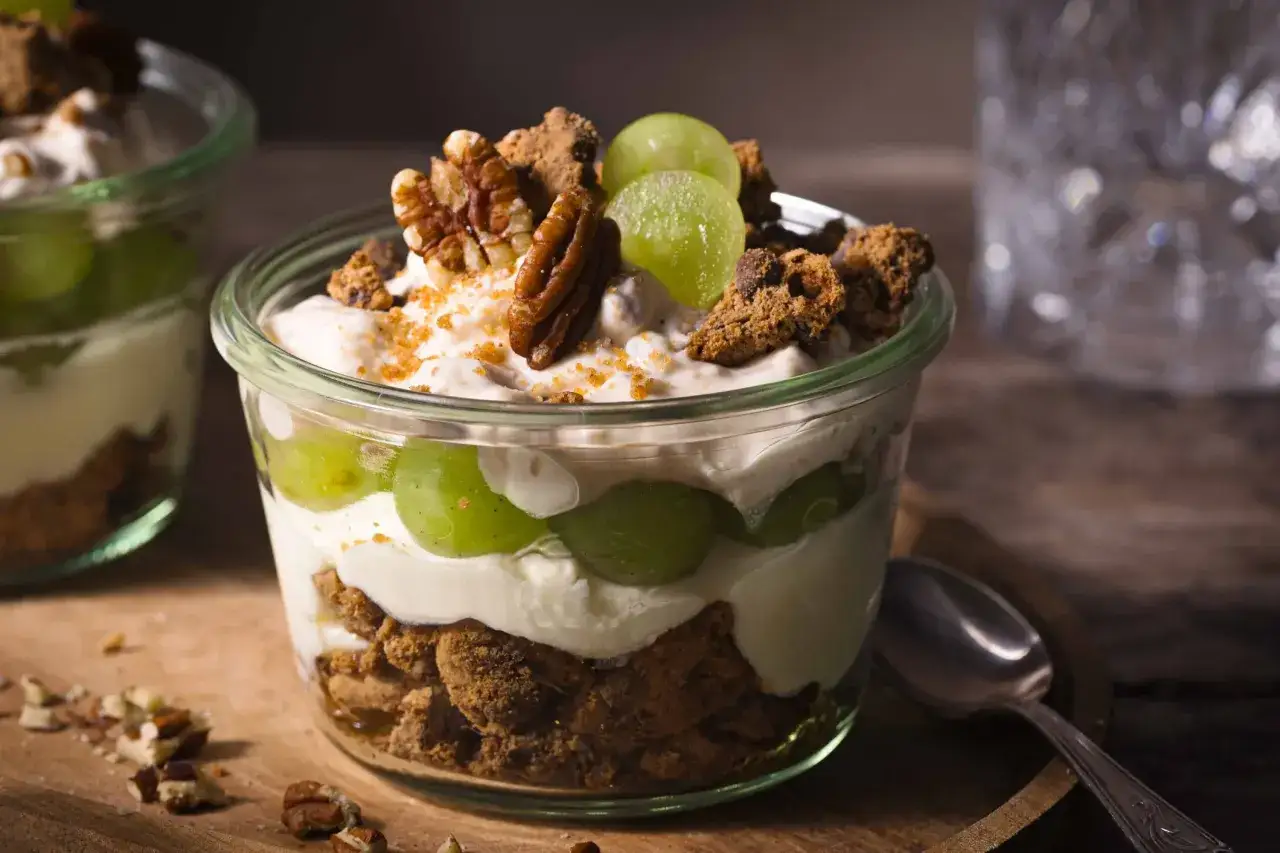 Ein k&ouml;stliches Dessert im Glas mit gr&uuml;nen Trauben, cremigem Joghurt, zerbr&ouml;selten Keksen und N&uuml;ssen. Ein s&uuml;&szlig;er Genuss!