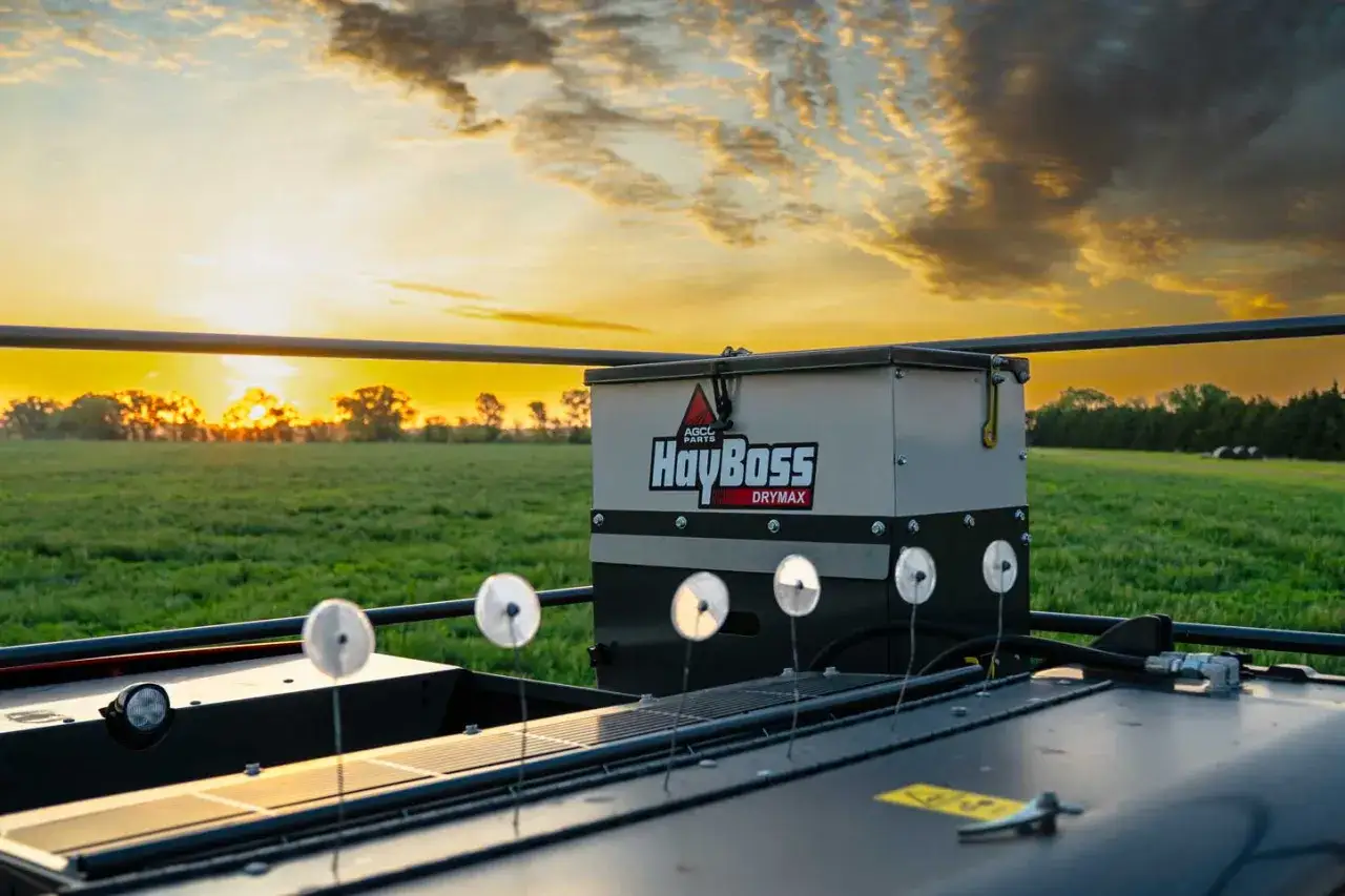 HayBoss DryMax machine in a field at sunset, ready to apply hay preservative to ensure quality feed.