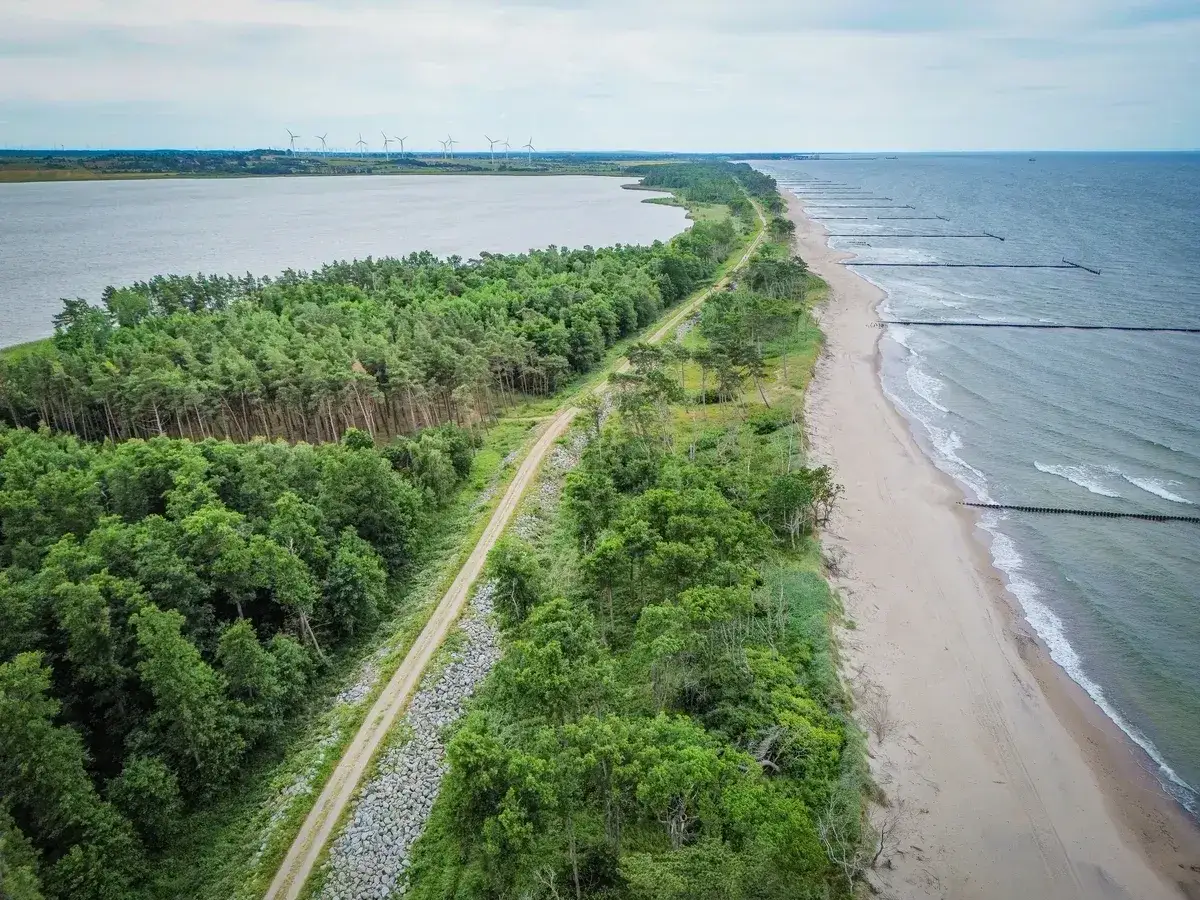 Piękna trasa nad morzem, idealna by sprawdzić, jak dojechać ze Sławna do Darłówka. Las, plaża i wiatraki w tle.