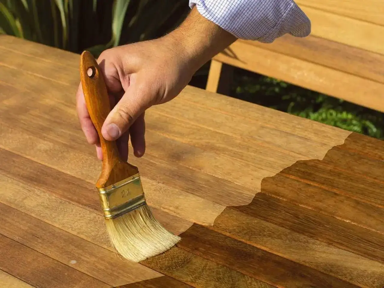 Aplicando aceite a una mesa de madera para protegerla sin barnizar.