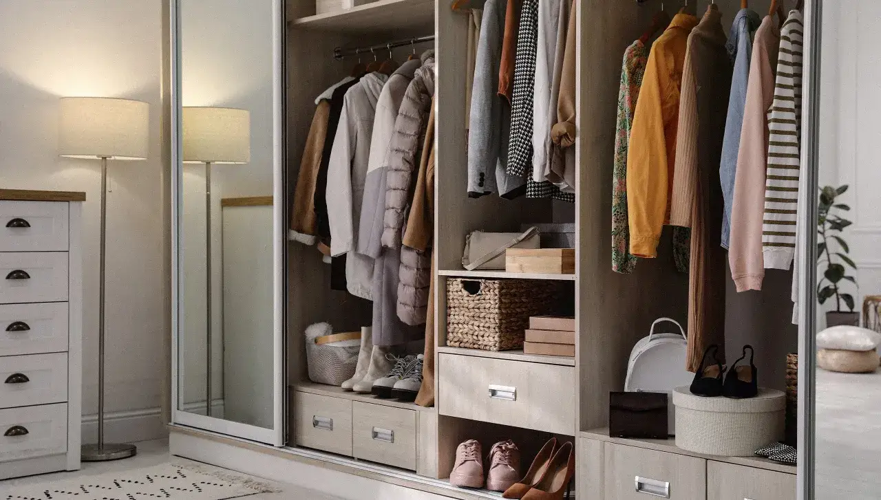 Armarios organizados con ropa colgada, cestas de mimbre, zapatos y accesorios. Un ejemplo perfecto de cómo organizar armarios para tener todo a mano.