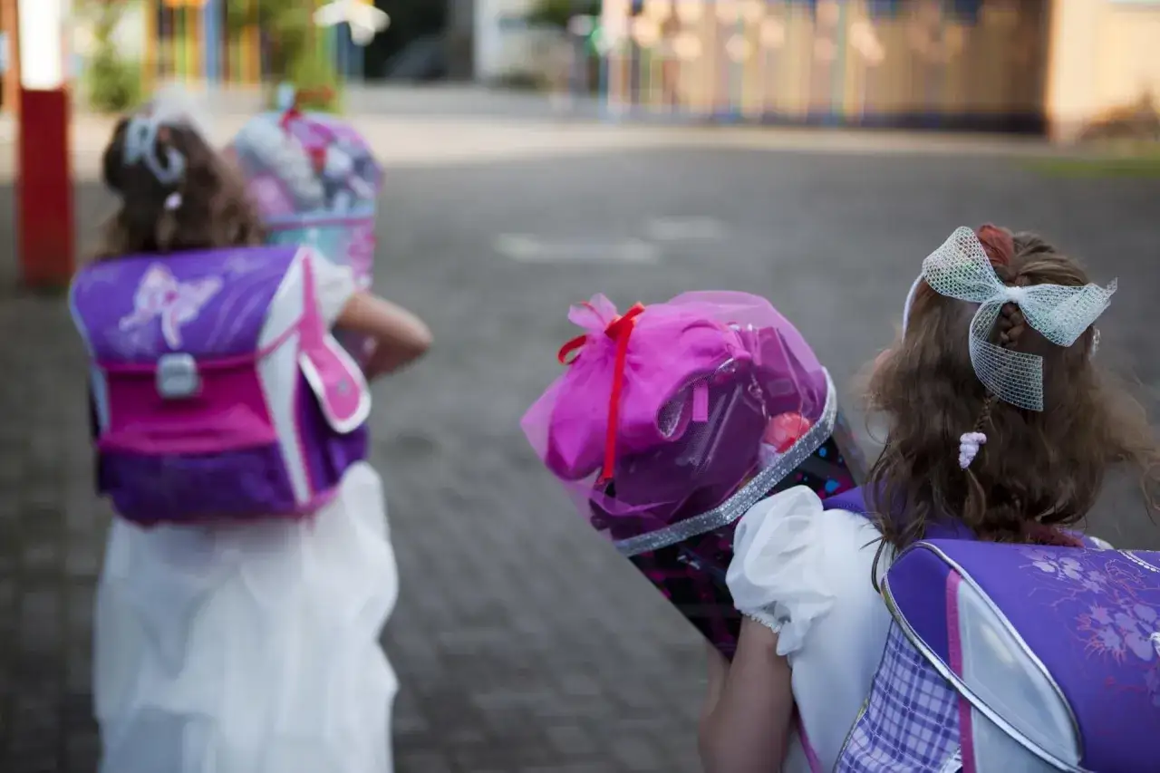 Zwei Mädchen mit Schultüten und lila Rucksäcken, bereit für die Einschulung. Tolle fotos einschulung ideen!