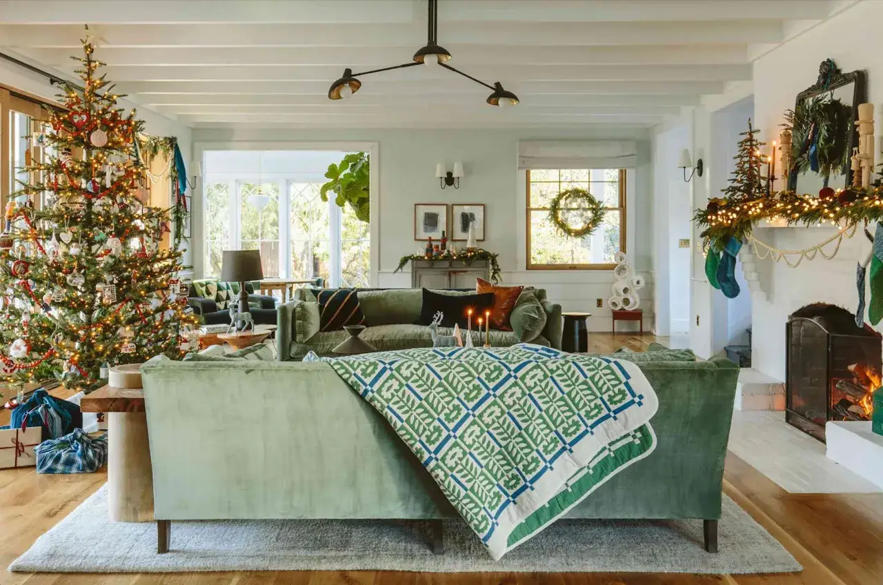 A cozy living room with a decorated Christmas tree, stockings hung by the fireplace, and a festive holiday design.