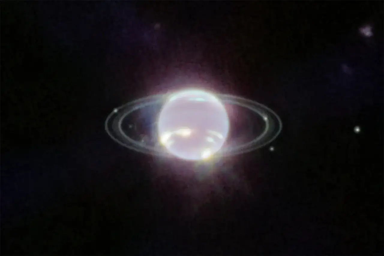 Neptunus ringar lyser i m&ouml;rkret, en s&auml;llsynt och vacker syn av den avl&auml;gsna planeten.