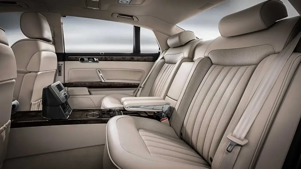 Lyxigt läderklädd baksäte i en VW Phaeton med armstöd och kontrollpanel.