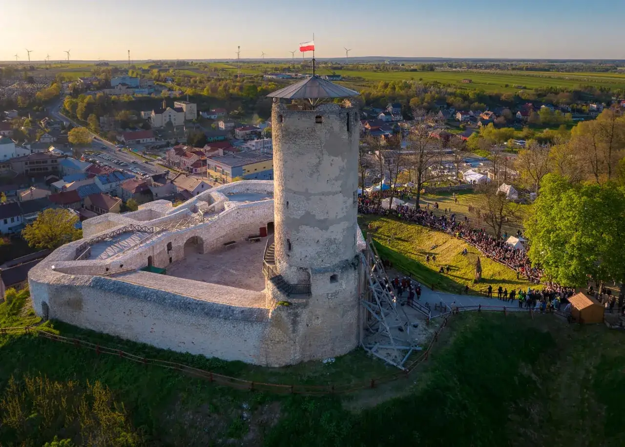 Iłża zamek z wieżą i murami obronnymi, na dziedzińcu i zboczu zgromadził się tłum ludzi.