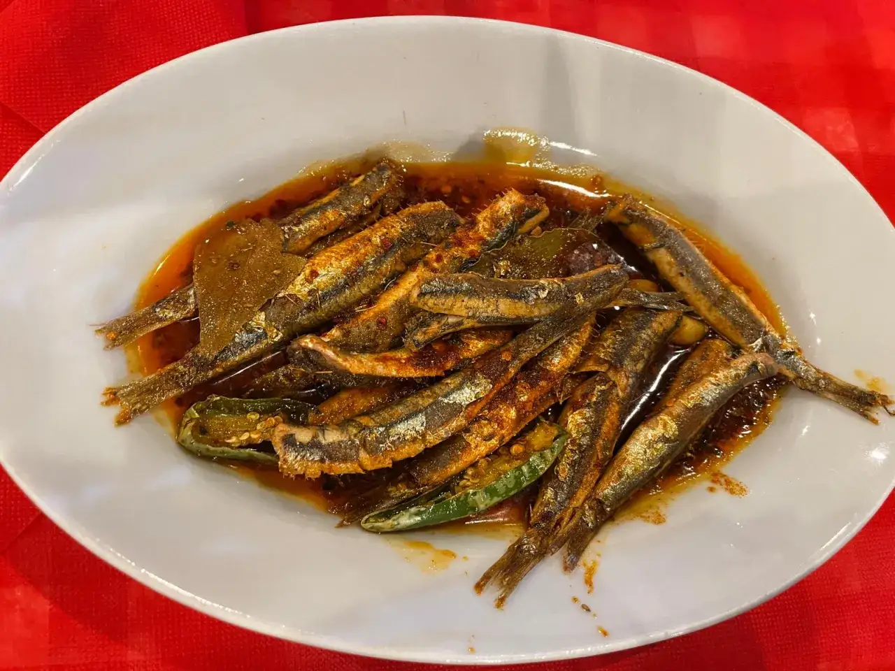 Piatto di alici marinate, un classico dei piatti tipici calabresi pesce, condite con olio, peperoncino e aromi.