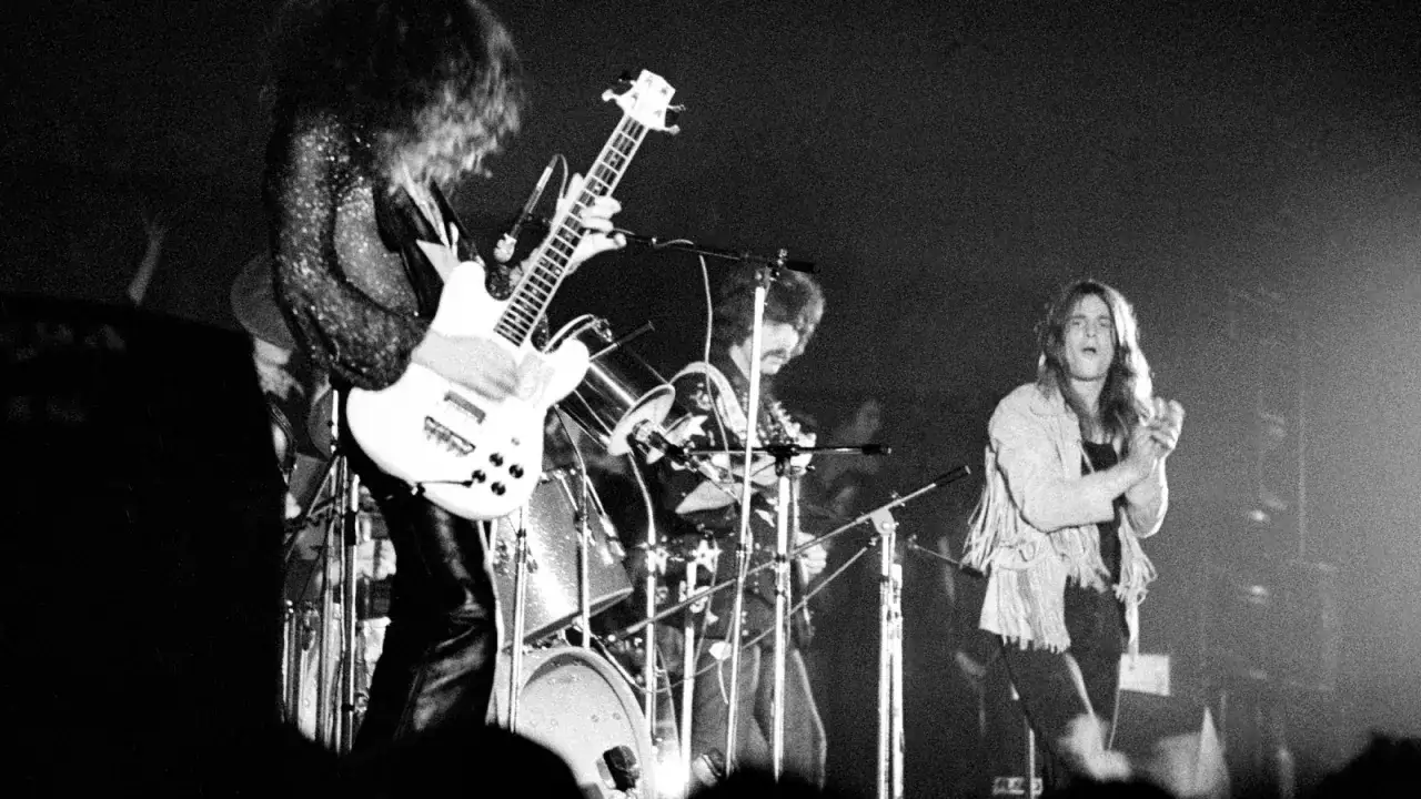 Ozzy Osbourne i zespół Black Sabbath na scenie, grający swoje legendarne utwory.