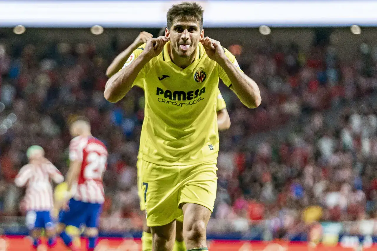 Gerard Moreno, con la camiseta amarilla del Villarreal, celebra un gol sacando la lengua y toc&aacute;ndose las orejas.