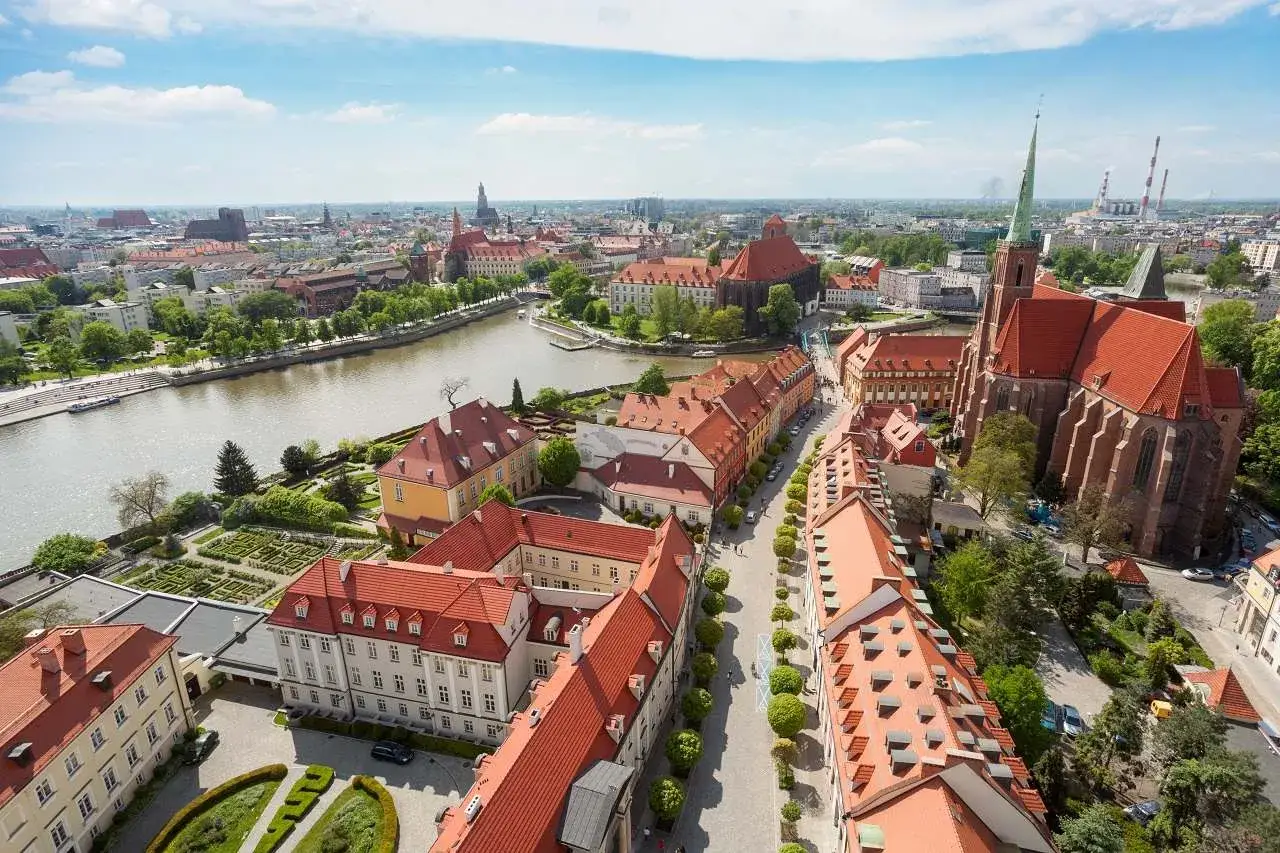 Wrocławskie wydarzenia na weekend: widok z lotu ptaka na Ostr&oacute;w Tumski, rzekę i zabytkowe kamienice. Idealne miejsce na spacer.