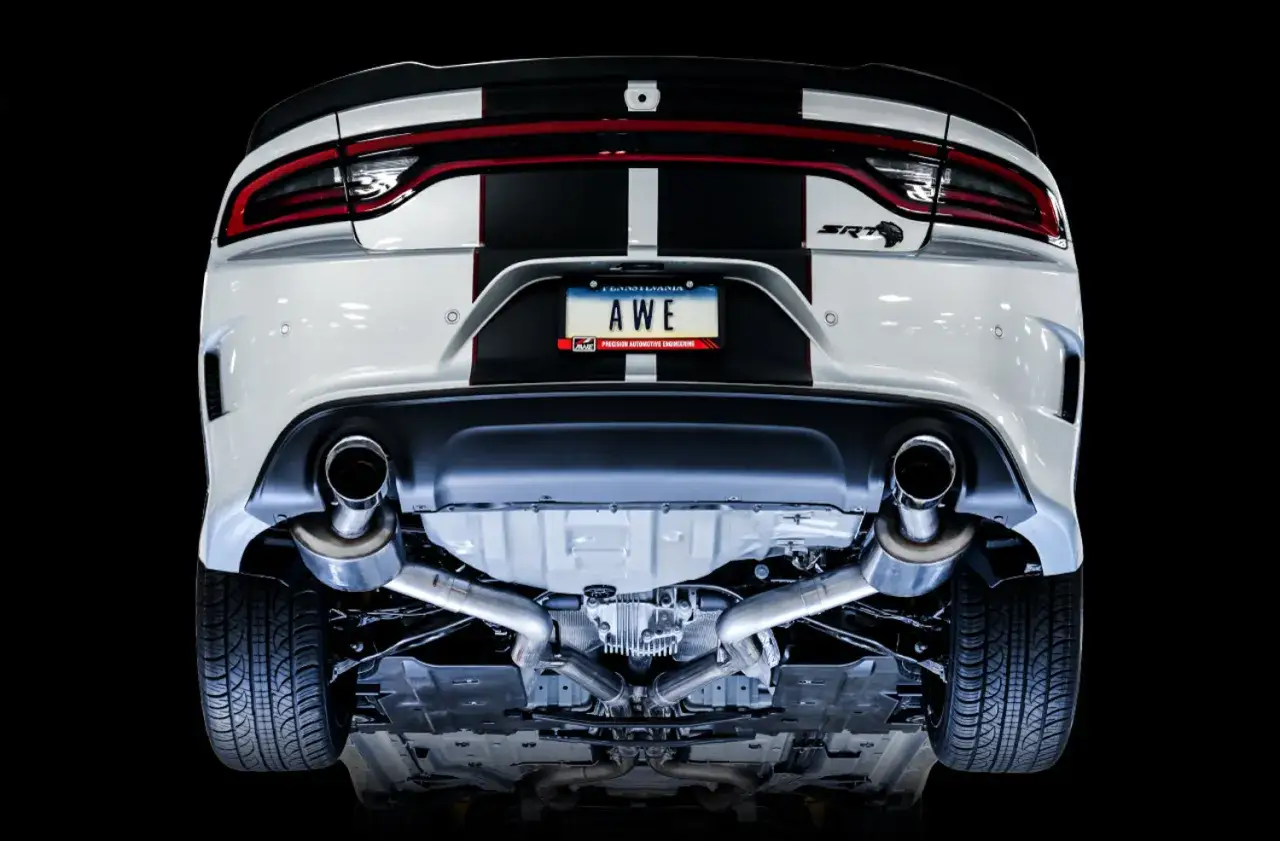 Tył białego Dodge Charger Hellcat z podwójnym wydechem i czarnymi pasami. Tablica rejestracyjna 