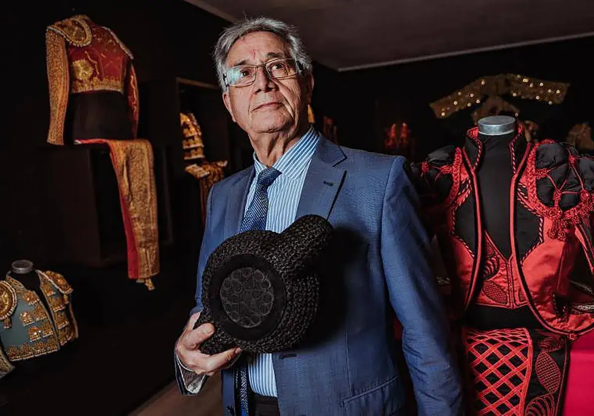Hombre con traje azul sostiene una montera, rodeado de trajes de luces. Justo algaba Madrid.