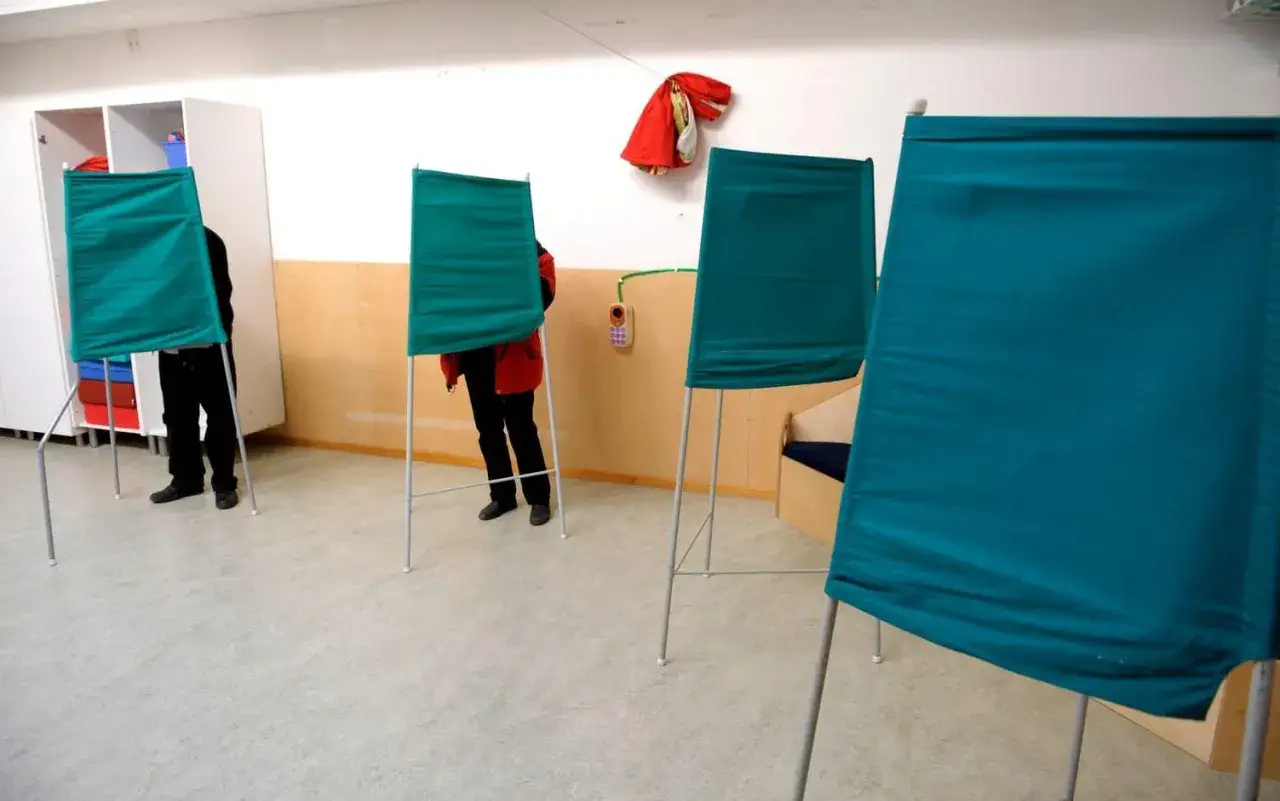 Valbås med gröna skärmar där medborgare utövar sin rätt till direkt demokrati.
