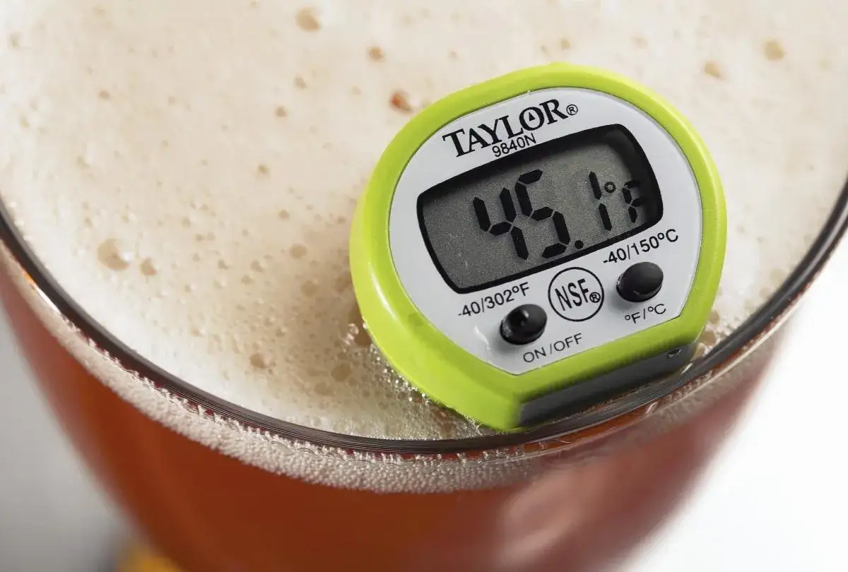 Termometro digitale in una birra schiumosa, ideale per controllare la temperatura perfetta, come da carta delle birre.
