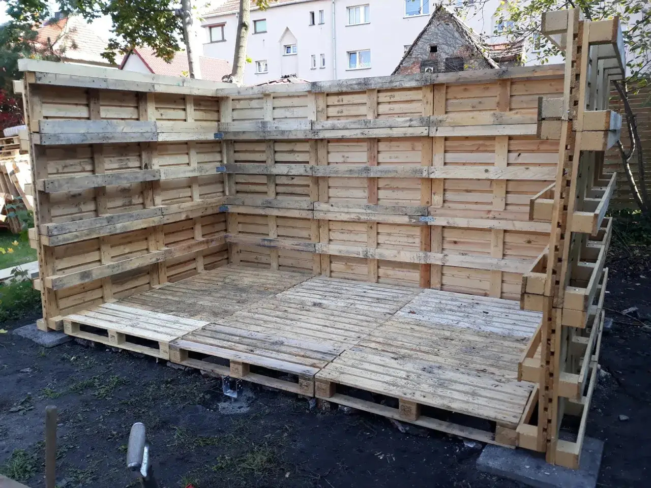 Budowa drewutni z palet. Projekt w toku, ściany i podłoga z drewnianych europalet.