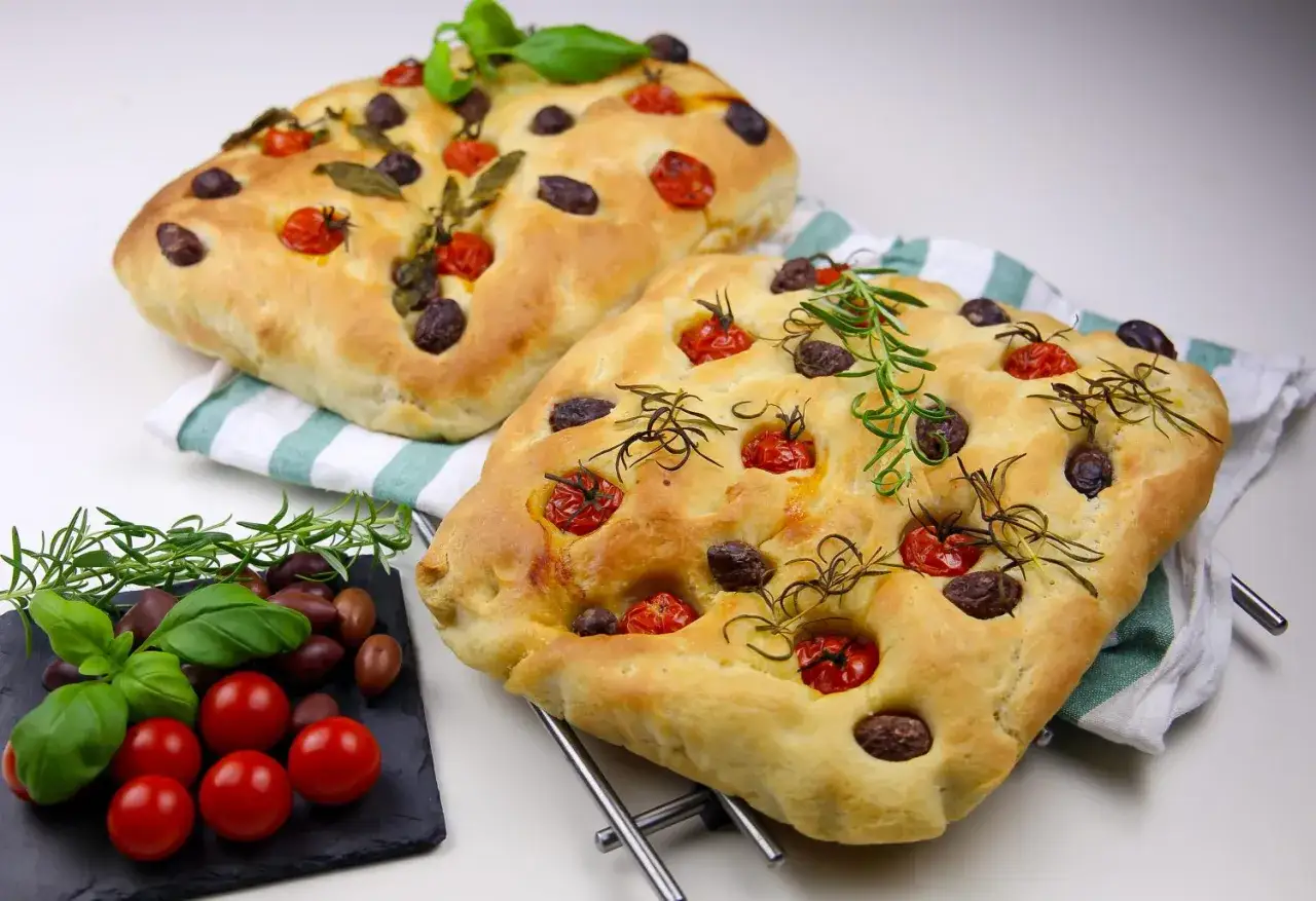 Tv&aring; gyllene focaccia med tomater, oliver och rosmarin. Perfekt f&ouml;r ett enkelt recept p&aring; focaccia.