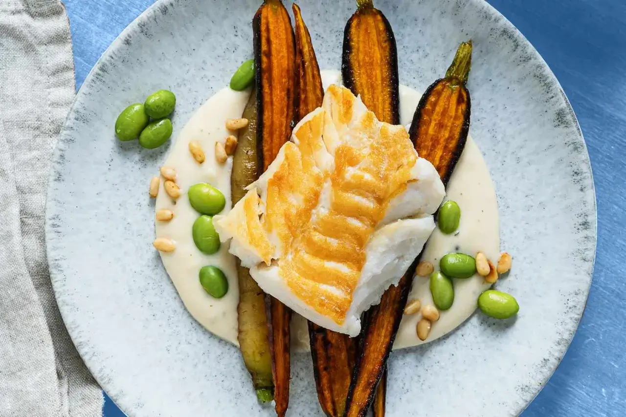 Filet de poisson blanc poêlé, servi avec des carottes rôties, des edamames et une sauce crémeuse. Le poisson est une excellente source de protéines, mais quelle viande en contient le plus ?