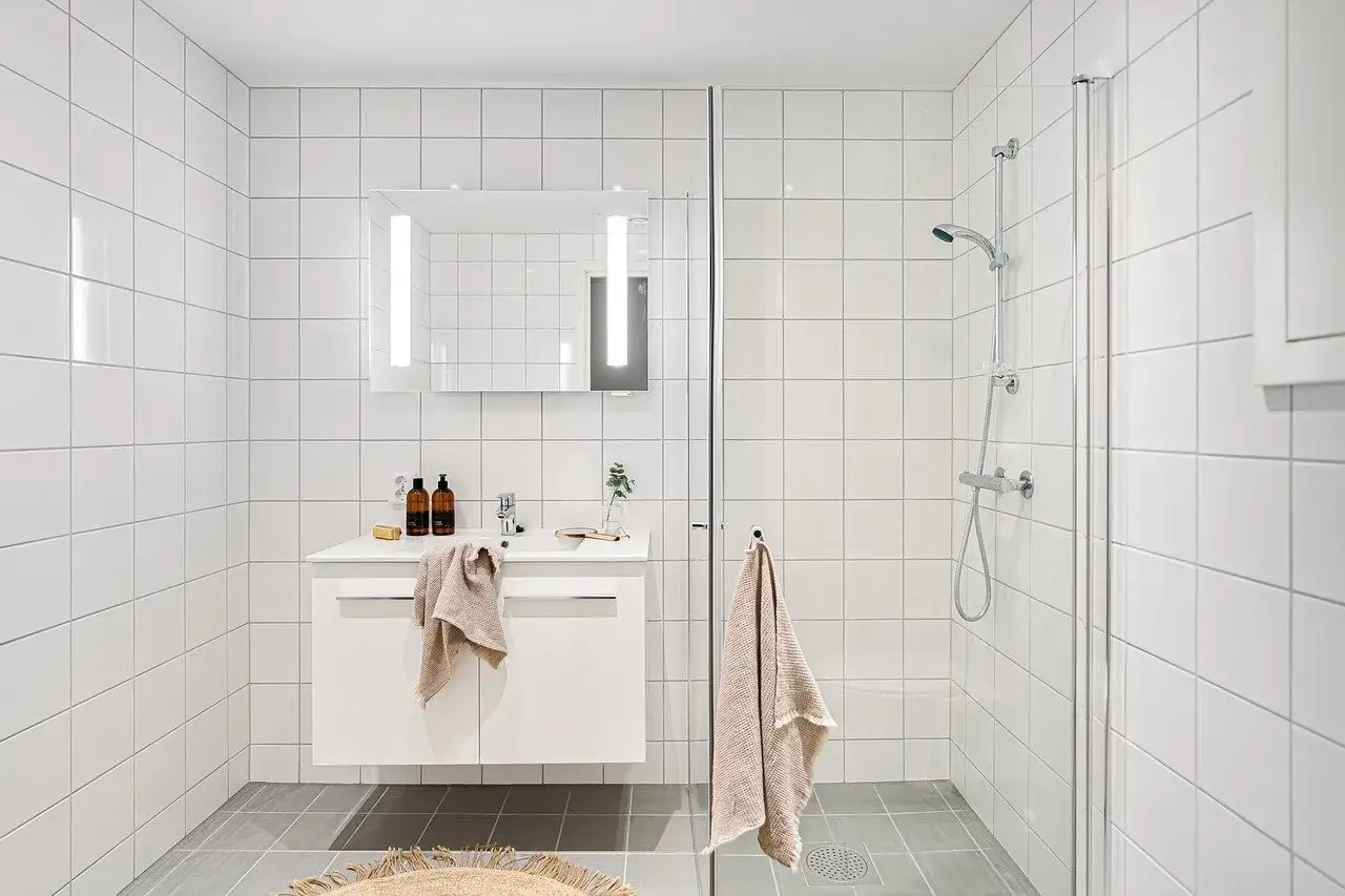 Modernes Bad mit Dusche und Waschbecken. Der wassererhitzer im Bad sorgt für warmes Wasser.