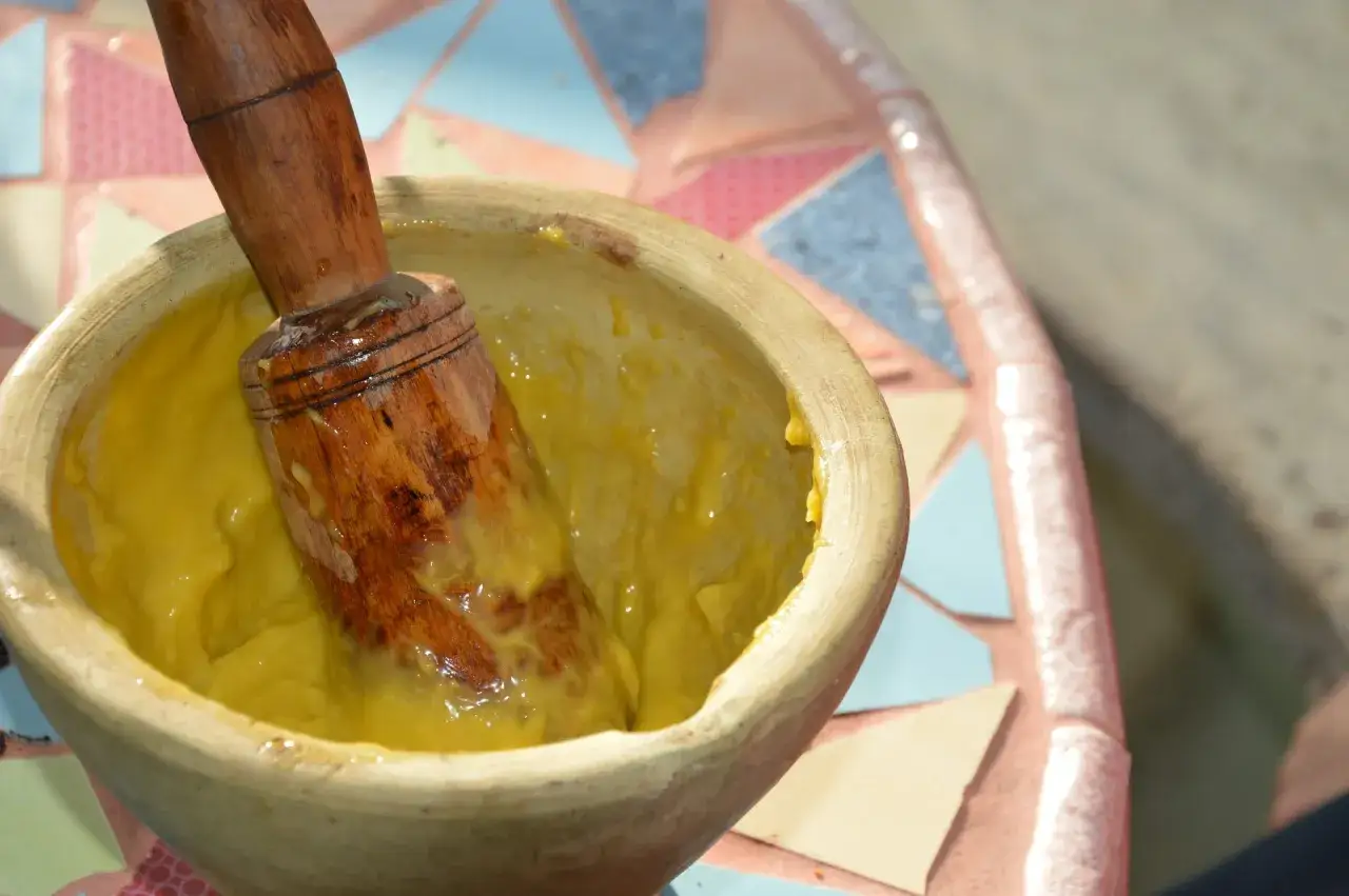 En mortel med en tr&auml;st&ouml;vel i en gul kr&auml;mig smet, perfekt f&ouml;r ett hemlagat aioli recept.